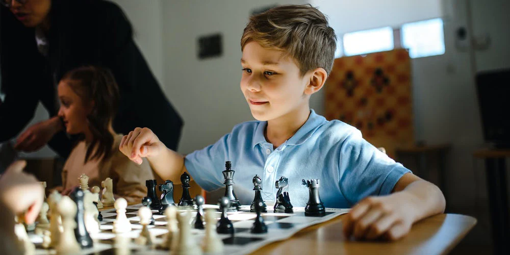 A young student focused on a chess game
